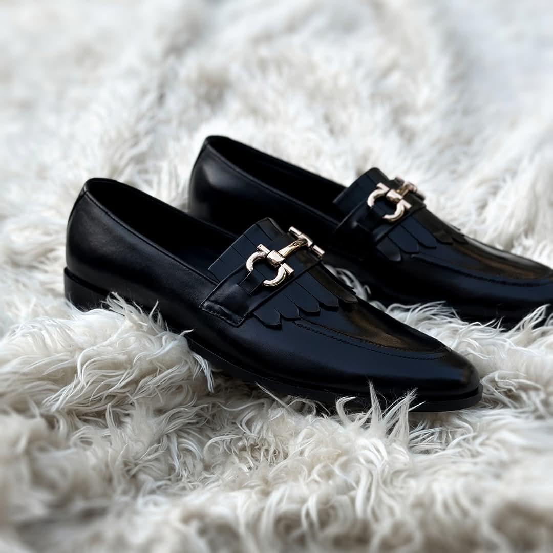 Black loafers with gold buckles